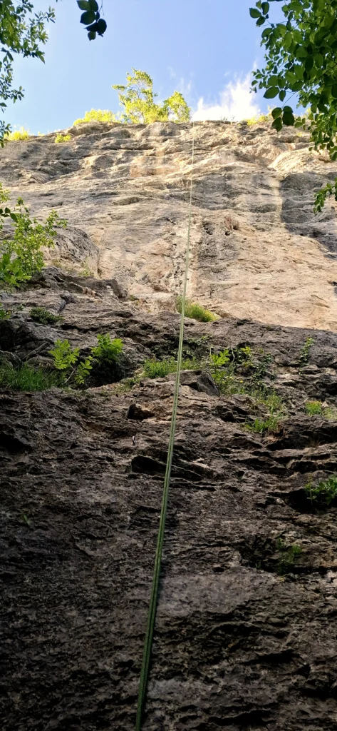 Blick auf eine Felswand. In der gekletterten Tour hängt noch ein Seil.